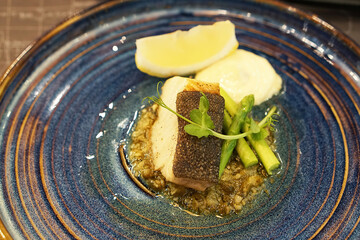 close up top view of sear cod fillet with lemon and asparagus, 