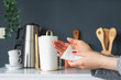 A woman wipes his hands with a paper towel in the kitchen. Napkins for care, domestic