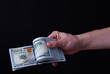 Man holding around 10000 American dollars, 100 USD banknotes.
