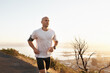© Katie/peopleimages.com - Athlete, man and running in road with music for sport, exercise and fitness for competition or marathon in nature. Runner, person and workout with wellness, seaside and earphones for cardio in Mexico