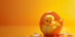 Little yellow chicks just hatched from an egg and sitting in the shell on a yellow background