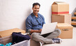 © Mariusz/peopleimages.com - Portrait, man and laptop by boxes in new house, apartment or property for moving, relocating or buying a home. Male person, real estate and mortgage for homeowner with computer, communication or tech