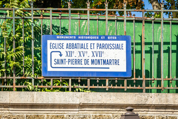 Wall Mural - Saint-Pierre de Montmartre church sign on a street of paris, France