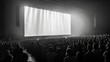 A black and white image of an enthralled audience, silhouetted against the radiant glow of a gigantic screen at a live event.