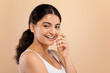 © Prostock-studio - Graceful young indian woman in white top gently touching her face