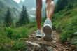 Close up of Low angle view of female legs, a jogger or hiker feet wearing colorful sports shoes on a mountain track. Trail running workout on rocky terrain outdoors, beautiful country road