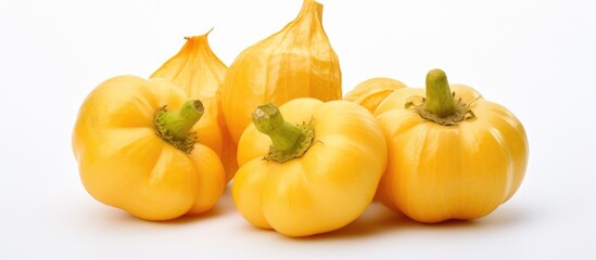 Wall Mural - A group of vibrant yellow bell peppers are arranged neatly on a plain white background. The peppers are fresh, with shiny skins and no visible blemishes, creating a visually appealing display.