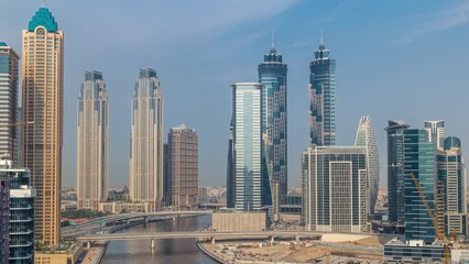 Wall Mural - Cityscape with skyscrapers of Dubai Business Bay and water canal aerial morning timelapse. Modern skyline with residential and office towers during sunrise. Sun reflected from glass surface