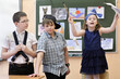 © Pavel Losevsky - two boys and one girl act out scene in class performance at drawing lesson