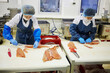  Workers cuts red fish in work shop of  Fish Factory. 