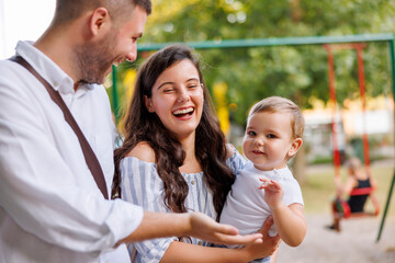 Wall Mural - Mother and father spending leisure time outdoors with their child