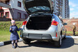 © Pavel Losevsky - Little girl standing with socket wrench and boy near open trunk of car