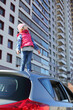 © Pavel Losevsky - Little girl in striped hat standing on top of car and looking up