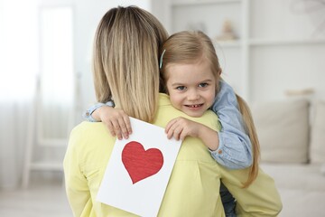 Wall Mural - Little daughter congratulating her mom with greeting card at home. Happy Mother's Day