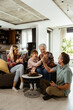 © BGStock72 - Joyous Family Celebrating Grandmothers Birthday With Cake in a Cozy Living Room