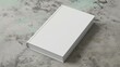 Hardcover closed blank book mockup on gray marble background, top view, flat lay, minimalism