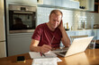 © Marko Geber - Stressed man going over bills at home
