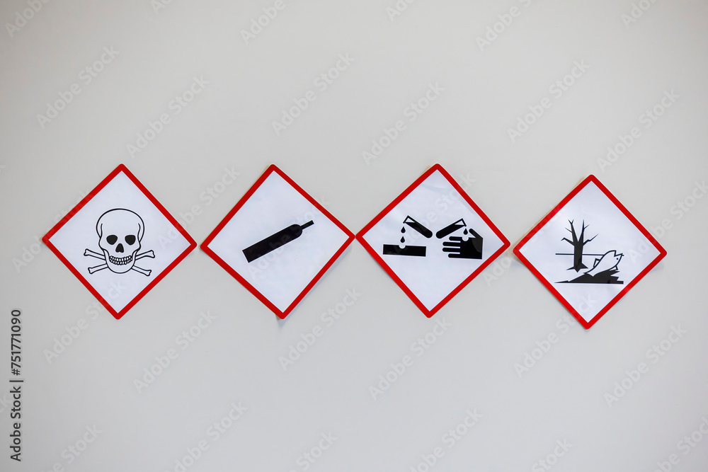 Four hazard warning signs with red diamond borders, depicting toxicity ...