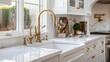 A striking kitchen faucet detail featuring white cabinets, a gold faucet, white marble countertops, and a brown picket ceramic tile backsplash