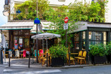 Fototapeta Paryż - Cozy street with tables of cafe  in Paris, France. Cityscape of Paris. Architecture and landmarks of Paris