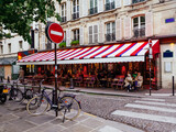 Fototapeta Paryż - Cozy street with tables of cafe in Paris, France. Cityscape of Paris. Architecture and landmarks of Paris