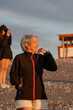 © Patricia Molaioli - Mujer mayor de 70 años feliz mirando el atardecer, vertical, plano medio