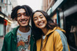 portrait of a happy couple in the city, asian young woman, brown man with dreadlocks, diveristy, smiling outdoors, wearing fashion casual streetwear, green yellow jackets tshirt relationship cheerful