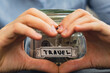 Unrecognizable woman showing heart sign Saving Money In Glass Jar filled with Dollars banknotes. TRAVEL transcription in front of jar. Managing personal finances extra income for future insecurity