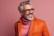 Portrait of a handsome senior man in orange coat and glasses.