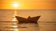 Paper boat sailing on sunset ,at the coean
