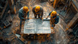 4 construction workers examining a blueprint on construction site. top view