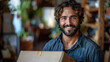 © tong2530 - A smiling young man mover worker in uniform holding a cardboard box and looking cheerful at camera standing in empty new apartment. Move, relocation and moving service concept.