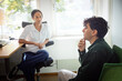 © Johnér - Male client talking with female counselor during therapy session in office