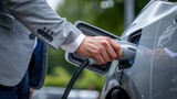 Fototapeta  - Close-up photo of a businessman using an electric car charger to charge his vehicle