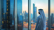 Successful arab businessman standing in his modern office looking at skyscrapers.