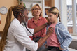 © Seventyfour - Side view portrait of female doctor listening to childs breathing with stethoscope during medical exam in clinic