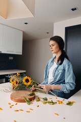 Wall Mural - Healthy, Beautiful Woman in a Modern Kitchen, Cutting Fresh Vegetables for a Tasty Salad