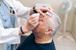 © Koldo_Studio - Doctor preps patient for glaucoma laser surgery with anesthetic.