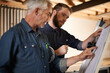 © Mikolette Moller/peopleimages.com - Architecture, team and men with blueprint for planning project, construction and creative. Engineer, apprentice and mentor with design, drawing and senior father with son for training at workshop