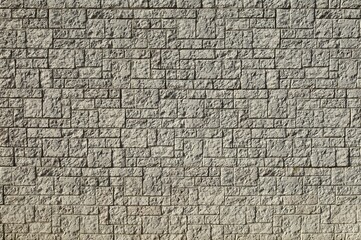 Wall Mural - Large concrete wall made of different shaped tiles imitating rough stone. Background and texture