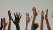 A diverse range of raised hands against a neutral background.