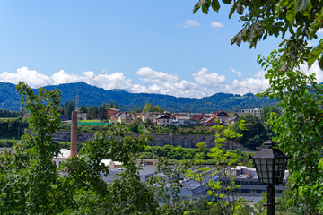 Wall Mural - Beautiful view with woodland and residential houses in the background at Slovenian City of Kranj on a sunny summer day. Photo taken August 10th, 2023, Kranj, Slovenia.