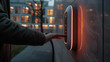 a man's hand turn on a charging station mounted on the wall of a residential building. Blur effect in the background