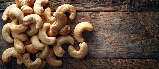 Wall Mural - A pile of cashews neatly arranged on top of a wooden table.