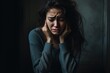 © dashtik - Depressed woman crying with head up on hands on dark background
