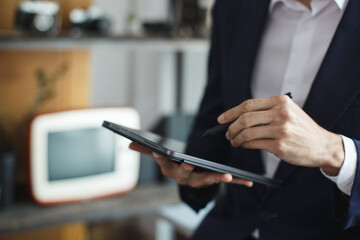 Poster - Closeup of digital tablet, successful businessman pointing typing touchpad working at office.