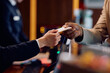 © Drazen - Close up of receptions giving cardkey to guest at hotel front desk.