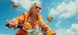 Fototapeta Natura - An elderly woman in vibrant clothing rides a scooter, displaying confidence and zest for life