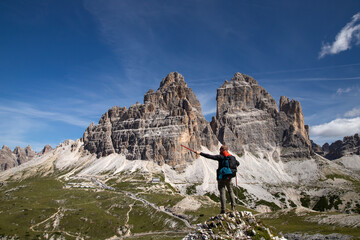 Wall Mural - Stunning view of a tourist enjoying the view of the Tre Cime Di Lavaredo, Dolomites, Italy.