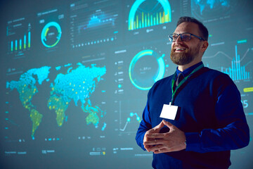 smiling businessman with glasses presenting analytical data visualizations on large screen. morning 